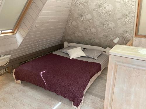 małe łóżko z fioletowym kocem w pokoju w obiekcie Estere w mieście Kieś