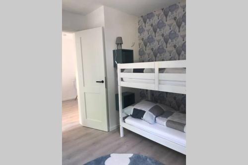 a small bedroom with a bunk bed and a door at Cosyinlaboe in Laboe