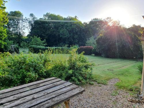 a wooden bench sitting in the middle of a garden at Ferme équestre & Chambres d'hôtes Gateau Stables proche Guédelon in Saint-Amand-en-Puisaye