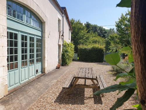 a wooden bench sitting in front of a building at Ferme équestre & Chambres d'hôtes Gateau Stables proche Guédelon in Saint-Amand-en-Puisaye