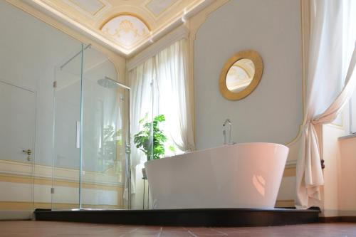 La salle de bains est pourvue d'une baignoire et d'une fenêtre. dans l'établissement Campana Suites, à Bibbiena