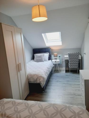 a bedroom with a bed and a desk and a window at Modern Holiday Home - Bundoran in Bundoran