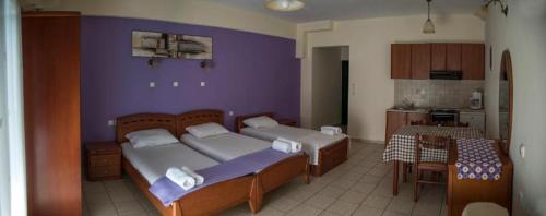 a bedroom with two beds and a kitchen with a table at Nature & Blue in Parga