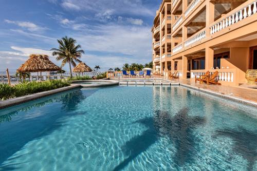 a swimming pool in front of a hotel at Hol Chan Reef Resort & Villas in San Pedro