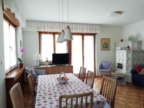 "Casa Elda" 110 mq primo Piano a Coredo TRENTO في كوريدو: غرفة طعام مع طاولة وكراسي وغرفة معيشة