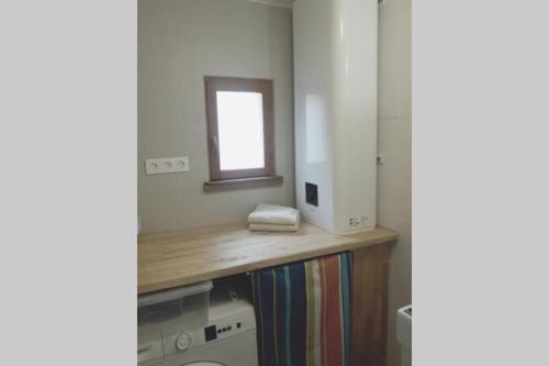 ein Badezimmer mit einer Holzoberfläche und einem Spiegel in der Unterkunft Maison de pêcheur près du port in Étaples