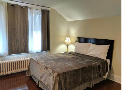 a bedroom with a large bed and a window at House in Niagara falls, Close to Clifton Hill, Casino and Horseshoe falls and with kitchen for 6 Guest in Niagara Falls