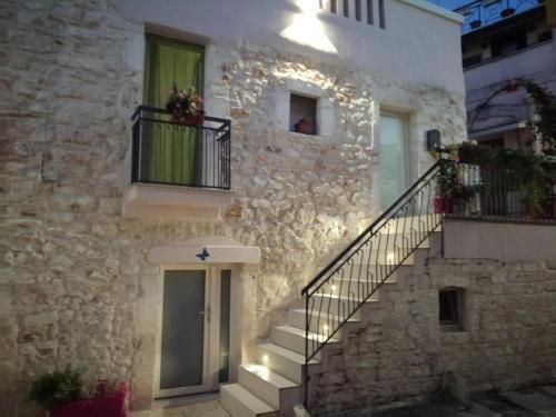 un edificio de piedra con escalera y ventana en Casa Giadi', en Cassano delle Murge