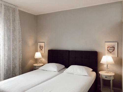 a bedroom with two beds and two tables with lamps at Letisija in Zadar