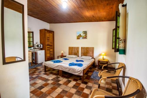 1 dormitorio con 1 cama, mesa y sillas en EcoLodge Paraty en Paraty