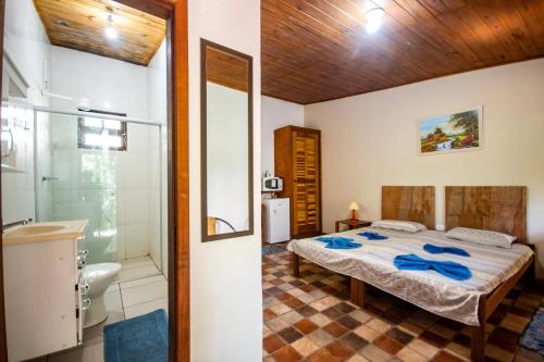 sypialnia z łóżkiem i prysznicem oraz łazienka w obiekcie EcoLodge Paraty w mieście Paraty