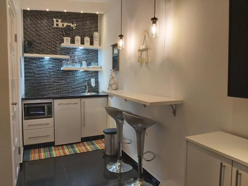 a kitchen with a counter and a bar in it at KDF Apartments in Willemstad