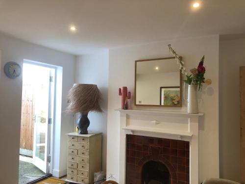 a living room with a fireplace and a mirror at Boutique City Centre Home in Chichester
