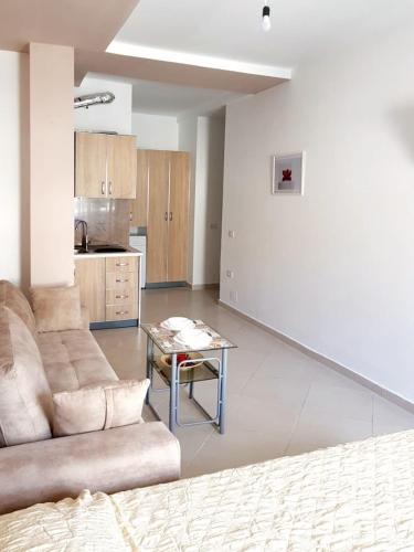 a living room with a couch and a table at Apartamenti Velvet in Shëngjin
