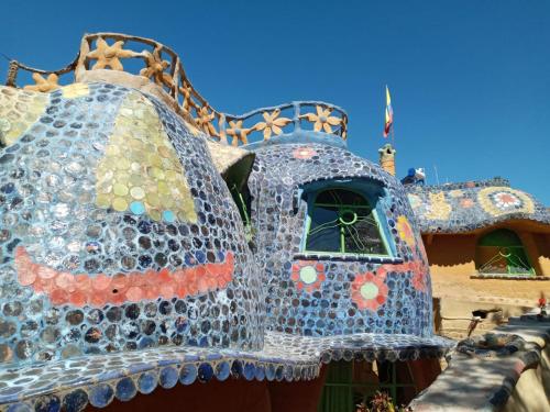 a building with a structure made out of wine bottles at CASA CERAMICA BELLA FLOR in El Laurel