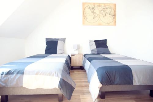 zwei nebeneinander stehende Betten in einem Schlafzimmer in der Unterkunft Maison neuve à 350m de la plage La casa Sovaïna in Cléder