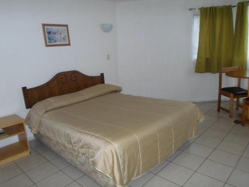 um quarto com uma cama, uma mesa e uma cadeira em Apart Hotel Fx em Puerto Montt