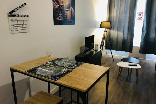 - un salon avec une table et des verres à vin dans l'établissement Le Studio 11 Abbeville centre baie de Somme, à Abbeville