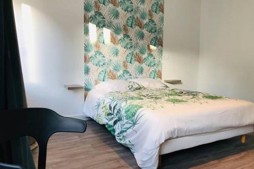 a bedroom with a bed with a tropical wallpaper at Le Wild Abbeville centre ville baie de Somme in Abbeville