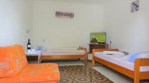 a room with two beds and a tv and a couch at 35 meters from sea Sweat house with garden in Karlobag