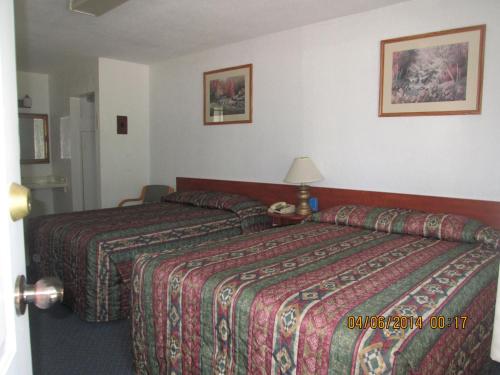 a hotel room with two beds and a lamp at Evening Star Motel in Greenwood
