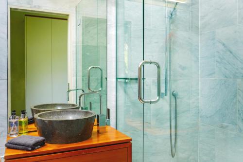 a bathroom with two sinks and a shower at Waterfall Bay Glass House in Picton