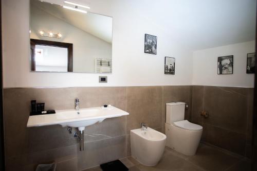 a bathroom with a sink and a toilet and a mirror at Maison Tuscany Bed&Breakfast in Sinalunga