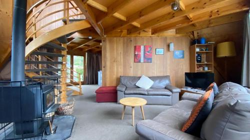 a living room with a couch and a fireplace at 9 Chalet Cres in Hanmer Springs