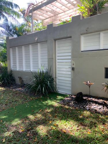a house with a garage door and a yard at Beachside 4 with private heated plunge pool in Port Douglas