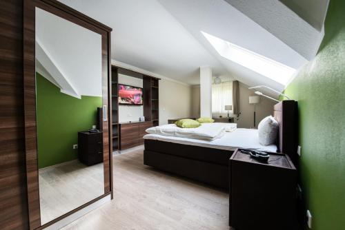 Hotel am Herkules في كاسيل: غرفة نوم مع مرآة كبيرة وسرير