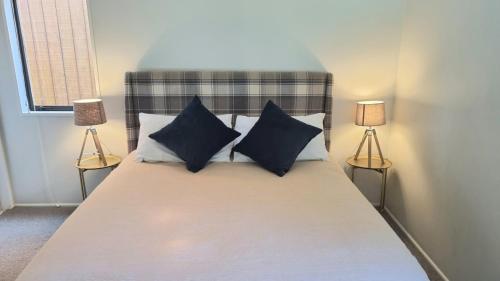 Un dormitorio con una cama con almohadas azules y dos lámparas. en 56 Conical Hill Road, en Hanmer Springs