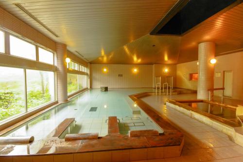 a large room with a swimming pool in a building at Hotel Epinard Nasu in Nasu