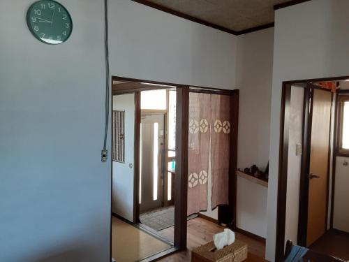 Habitación con espejo y reloj en la pared en Hallelujah, en Morohongō