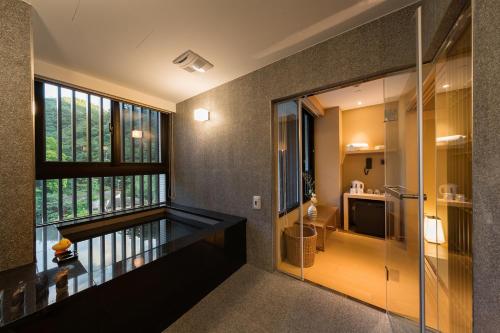 a room with a balcony with a view of a bathroom at Asia Pacific Hotel Beitou in Taipei