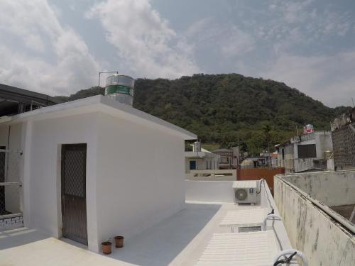 a white building with a mountain in the background at PageSurfingInn in Donghe