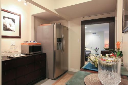 a kitchen with a stainless steel refrigerator and a microwave at Overlooking Marina del Rey sailboats, is Green Ginger Playa Del Rey on the bluff, in Los Angeles