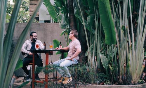 two men sitting at a table with glasses of wine at Monkey Republic Kampot in Kampot