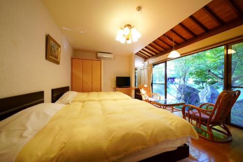 a bedroom with a large bed and a large window at Beppu Showaen in Beppu