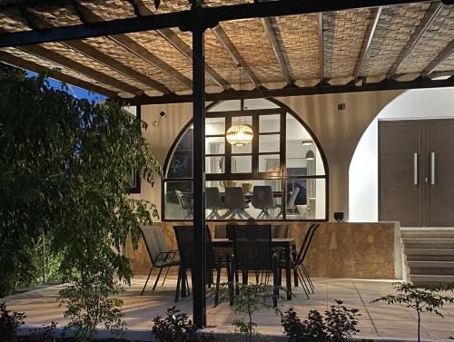 a patio with a table and chairs under a pergola at Villa Athasia in Yiolou