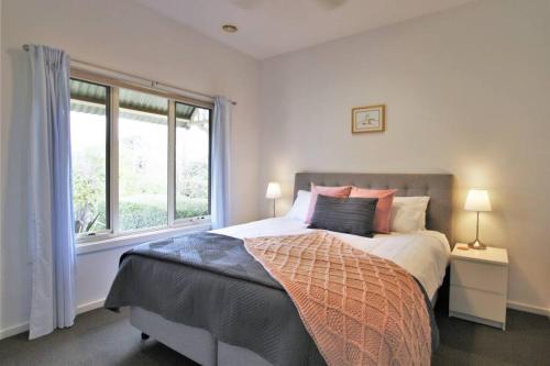 a bedroom with a large bed and a window at Fermoy Cottage in Healesville