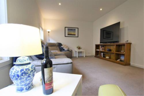 a living room with a bottle of wine on a table at Fermoy Cottage in Healesville