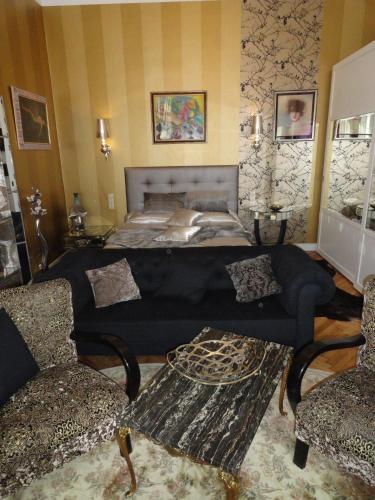 a living room with a bed and a couch at Boudoir Budapest Apartment in Budapest