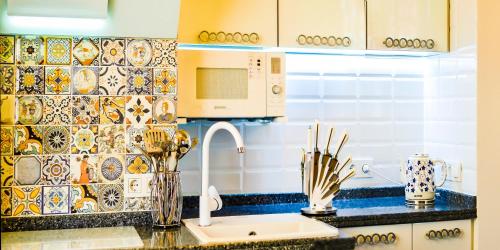 a kitchen with a sink and a microwave at Kapitan Apartments in Odesa