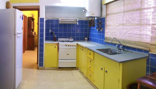a kitchen with yellow cabinets and a white stove at Cabañas Mi Refugio in Villa Giardino
