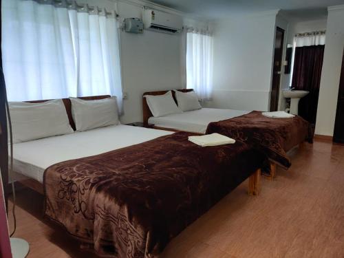 a hotel room with two beds and a couch at Shalom Beach Residency in Alleppey