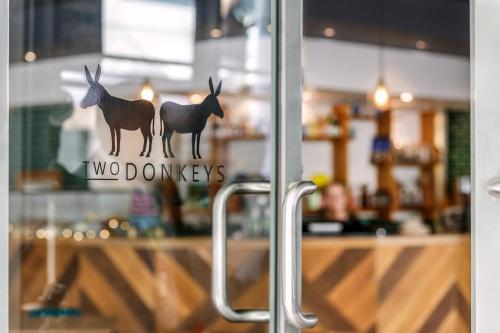 a glass door with a sign with two deer on it at Amora Hotel Brisbane in Brisbane