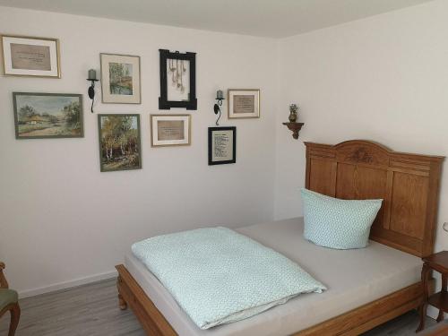 een slaapkamer met een bed met een hoofdeinde en foto's aan de muur bij Ferienwohnungen Elsen in Schwebheim