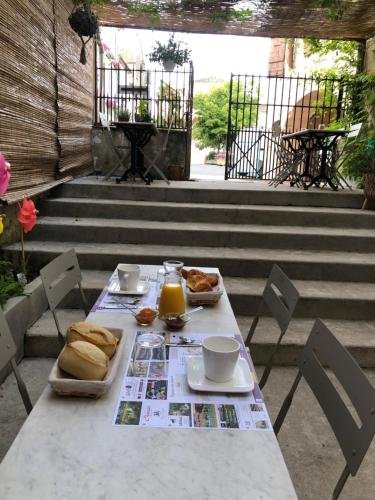 Les Chambres du Montréal et l'Hôtel particulier في مونتريال: طاولة مع الخبز وعصير البرتقال على الفناء
