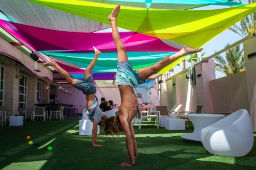 two people doing a handstand under a tent at Abraham Eilat in Eilat