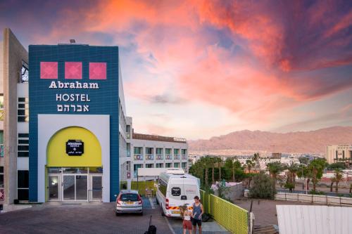 een hotel met een busje geparkeerd op een parkeerplaats bij Abraham Eilat in Eilat